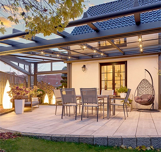 Gepflasterte Terrasse mit großer Terrassenüberdachung, Dekorationen, Gartenlounge und Beleuchtung