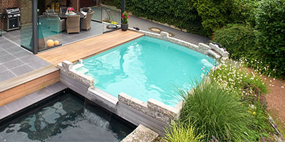 An Terrasse angebauter Pool der in ein fließendes Wasserspiel überläuft